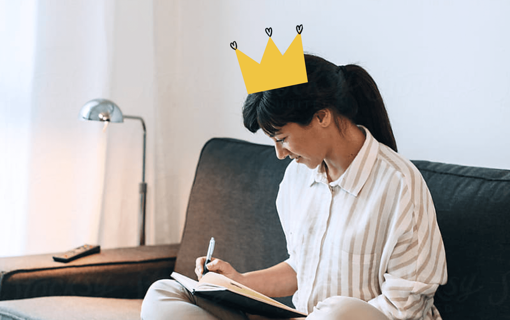 Kobieta siedzi na kanapie i notuje w notatniku. Panuje przytulna i produktywna atmosfera.