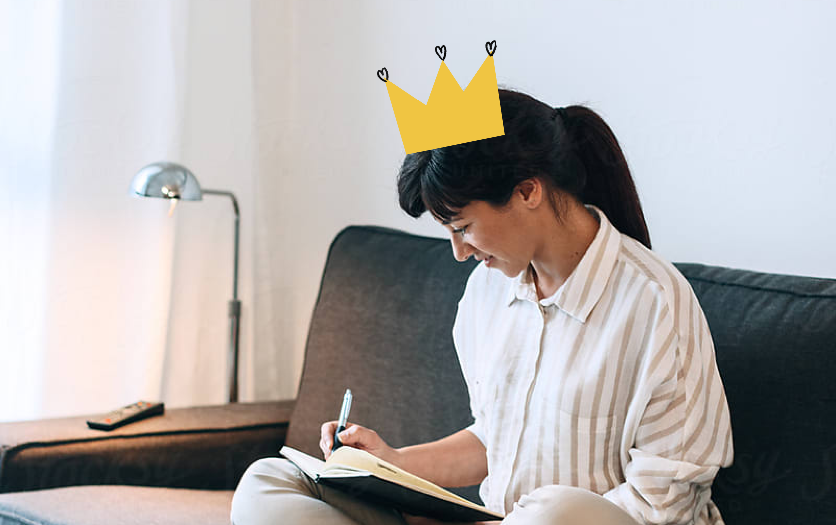 Kobieta siedzi na kanapie i notuje w notatniku. Panuje przytulna i produktywna atmosfera.